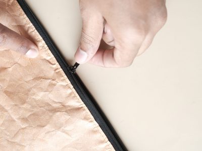 hand in a Zipper on a small paper bag ,